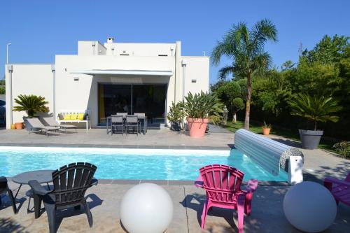 una piscina con 2 sillas, una mesa y una casa en Villa de standing Piscine privée à 15 min des plages 8VB11, en Perpiñán