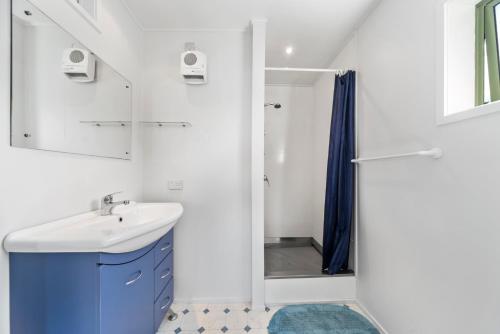 a white bathroom with a sink and a shower at Lakeside Terrace - Taupo Holiday Home in Taupo