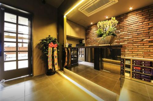 a room with a brick wall and a counter with plants at Hotel Daisy in Seoul