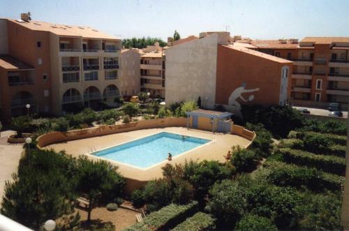 une vue aérienne d'une piscine dans un immeuble dans l'établissement ANTINEA Joli T2 cabine piscine proche plage Richelieu cap d'Agde, au Cap d'Agde