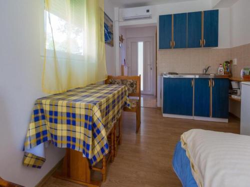 a kitchen with blue cabinets and a table in a room at Apartments Adrasteja in Dramalj