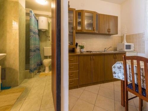 a kitchen with a toilet a sink and a microwave at Apartments Adrasteja in Dramalj