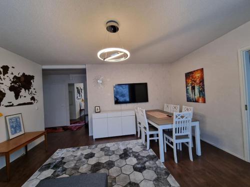 a living room with a table and chairs and a tv at Valoisa huoneisto jossa erinomaiset vuoteet. in Mikkeli