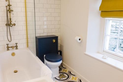a bathroom with a tub and a toilet and a sink at May Tree Cottage Manorbier 5 mins from the beach Sleeps 4 in Manorbier
