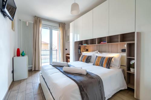 a bedroom with a large white bed and a balcony at Il Nido di Sesto - Vicino a Milano in Sesto San Giovanni