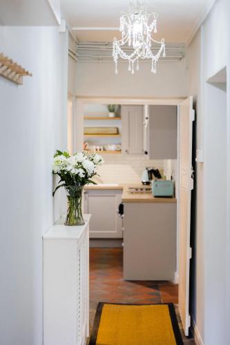a kitchen with a vase of flowers on a counter at May Tree Cottage Manorbier 5 mins from the beach Sleeps 4 in Manorbier