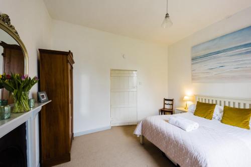 a bedroom with a bed and a painting on the wall at May Tree Cottage Manorbier 5 mins from the beach Sleeps 4 in Manorbier