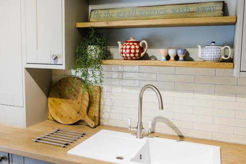 a kitchen with a sink and a counter top at May Tree Cottage Manorbier 5 mins from the beach Sleeps 4 in Manorbier