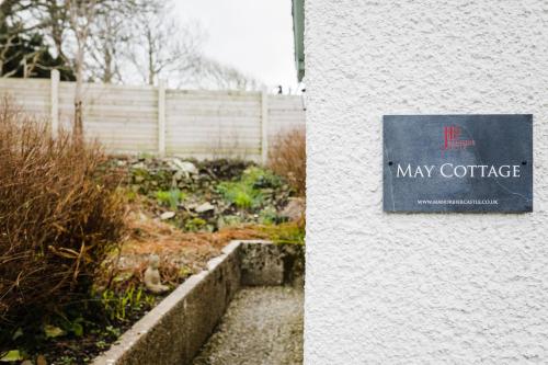 a sign for may cottage on the side of a building at May Tree Cottage Manorbier 5 mins from the beach Sleeps 4 in Manorbier