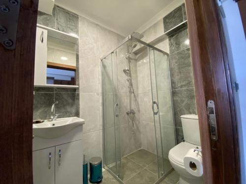 a bathroom with a shower and a toilet and a sink at ATAŞ AQUA OTEL AVŞA in Samanlı