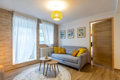 salon z kanapą i stołem w obiekcie Le 05-GregIMMO-Appart'Hôtel w mieście Montbéliard