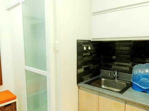 a kitchen with a sink and a glass window at The Levels 2BR Condo Fully Interior Cosmo Living in Manila