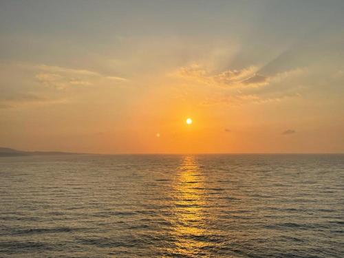 a sunset over the ocean with the sun in the sky at El Rancho Busto - Luarca in Busto