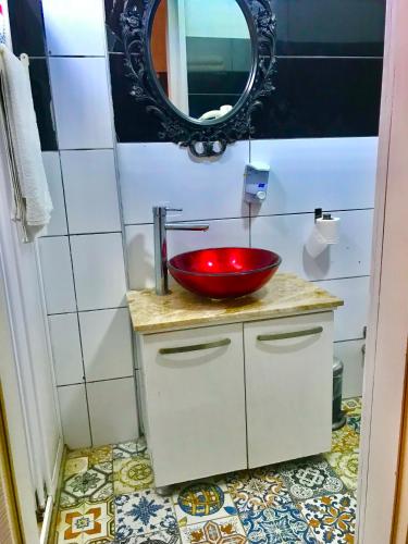 a bathroom with a red sink and a mirror at Hotel Barba in Urla