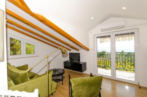 a living room with green chairs and a balcony at House Ratac in Bol