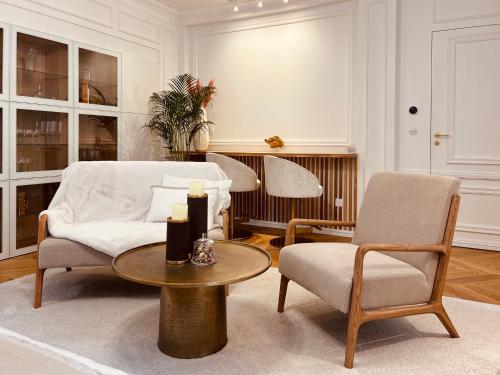 een woonkamer met 2 stoelen en een tafel bij Hotel Particulier La Defense - Boutique Hotel Paris in Puteaux