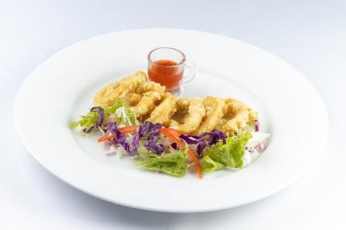 a white plate of food with a salad and shrimp at Maalu Maalu Resort & Spa - Thema Collection in Pasikuda