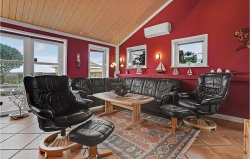 a living room with black leather furniture and red walls at 4 Bedroom Awesome Home In Egernsund in Egernsund