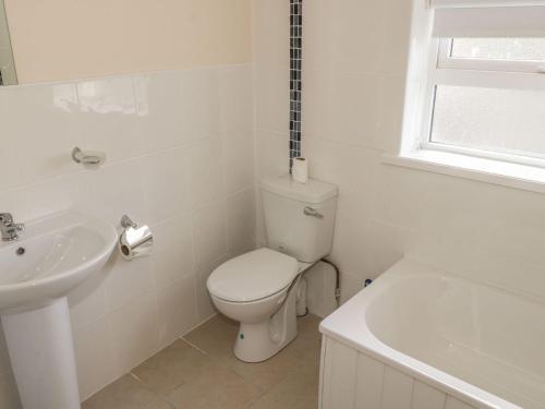 bagno bianco con servizi igienici e lavandino di Glebe House a Ballinrobe