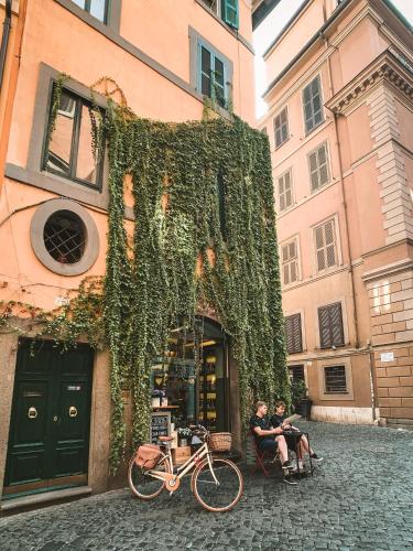 two people sitting outside of a building with a bike at Nerva Boutique Hotel in Rome