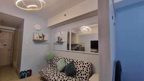 ein Wohnzimmer mit einem Sofa und einem Spiegel in der Unterkunft EZBeds Mall of Asia in Manila