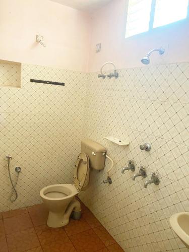 a bathroom with a toilet and a sink at Homestay - Heaven Aumgarden in Trivandrum
