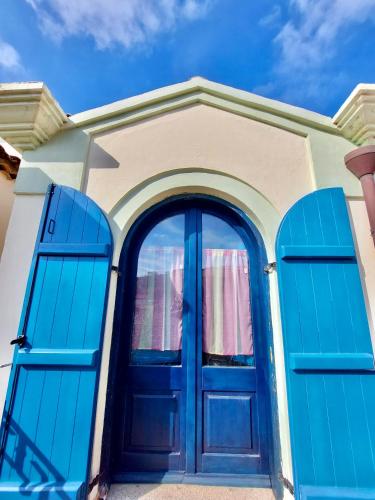 a blue door on a house with blue windows at Jennas-Grecale Apartment in Àrbatax