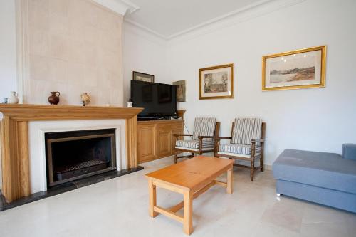 a living room with a couch and a fireplace at Llampudol -Villa Sa Coma- in Sa Coma