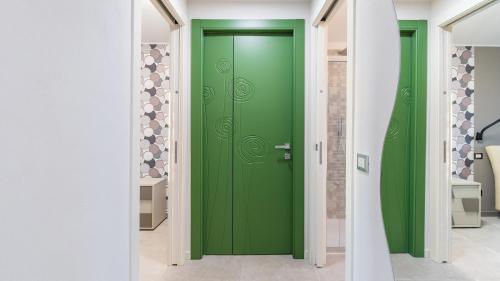 una puerta verde en una habitación con paredes blancas en TRAMONTO ALBESE 4, Emma Villas, en Montelupo Albese