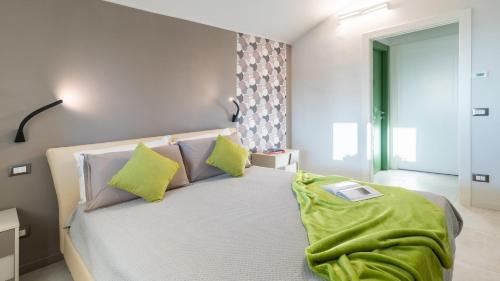 Un dormitorio con una cama con una manta verde. en TRAMONTO ALBESE 4, Emma Villas, en Montelupo Albese