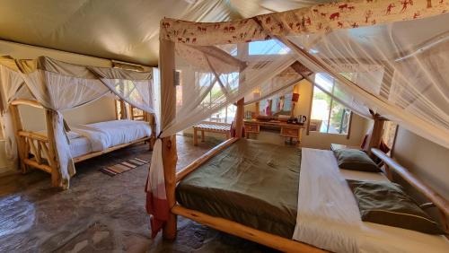 a bedroom with two bunk beds and a mirror at Manyatta Camp in Voi