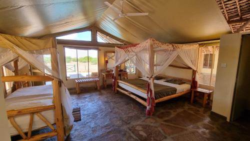 a bedroom with two bunk beds and a window at Manyatta Camp in Voi