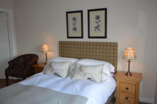 a bedroom with a bed with white sheets and pillows at Balnearn House in Aberfeldy