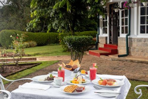 a white table with plates of food on it at Mountbatten Bungalow- Thema Collection in Kandy