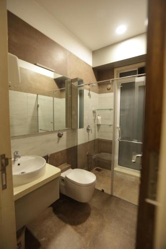 a bathroom with a toilet and a sink and a shower at Artist House 3BR By Flora Stays in Mumbai