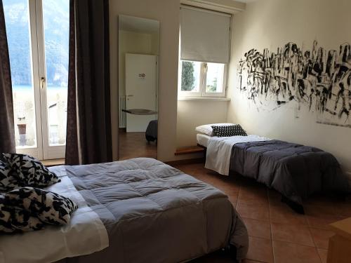 a bedroom with two beds and a painting on the wall at Caffè del Viaggiatore in Valsolda