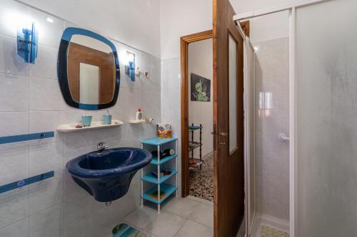 y baño con lavabo azul y ducha. en Casa Lamarmora, en Nebida