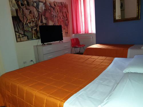 a hotel room with two beds and a television at Caffè del Viaggiatore in Valsolda