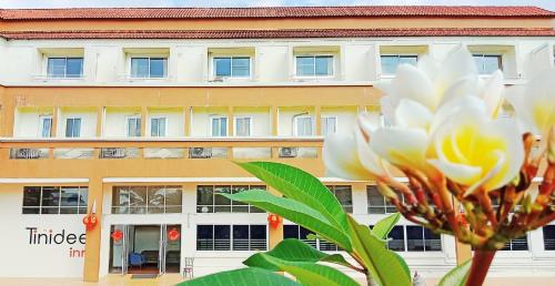 un edificio con una flor blanca delante de él en Tinidee Inn Ranong, en Ranong