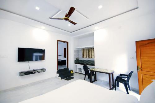 1 dormitorio con 1 cama y ventilador de techo en GV Resort, en Yercaud
