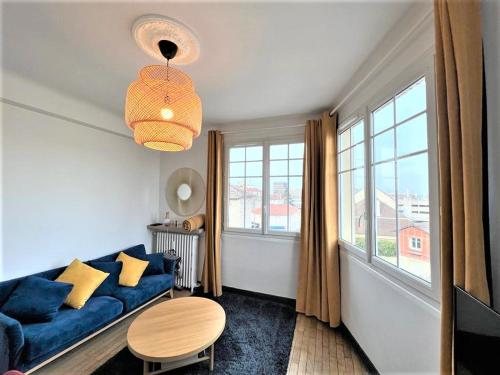 a living room with a blue couch and a table at SUPERBE APPARTEMENT 2 PIECES A 200 METRES GARE in Melun