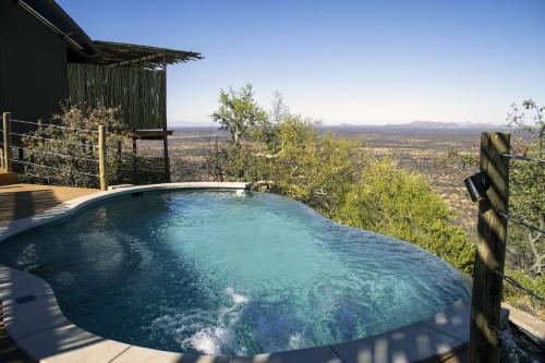 a hot tub with a view of the desert at TimBila Safari Lodge in Omaruru