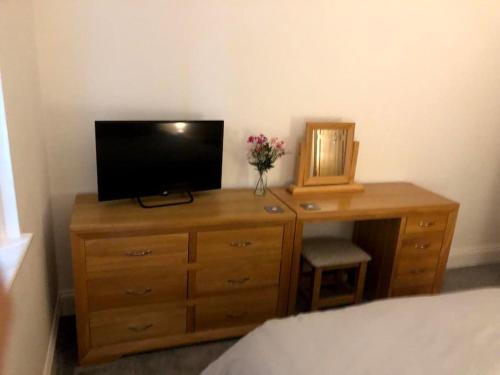 um quarto com uma cómoda, uma televisão e uma secretária em The Old Ship Hotel, apartment 2 em Skipton