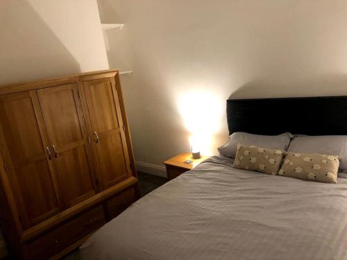 a bedroom with a bed and a wooden cabinet at The Old Ship Hotel, apartment 2 in Skipton