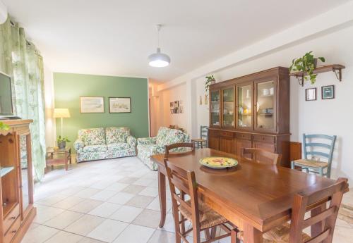 uma sala de estar com uma mesa de madeira e cadeiras em Giarranas House - Apartment with coutyard em Villacidro