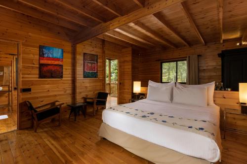 a bedroom with a large bed in a log cabin at Mountbatten Bungalow- Thema Collection in Kandy