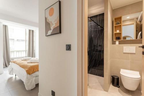 łazienka z łóżkiem, toaletą i prysznicem w obiekcie Magnifique Appartement 5 stars - Parking - Terrasse - 3 Mins De La Croisette - Palais Royal by Halldis w Cannes