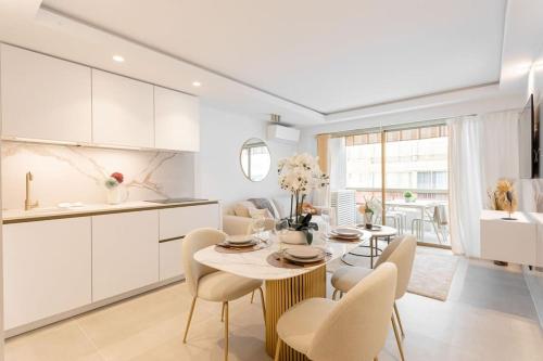 une cuisine et une salle à manger avec une table et des chaises dans l'établissement Magnifique Appartement 5 stars - Parking - Terrasse - 3 Mins De La Croisette - Palais Royal by Halldis, à Cannes