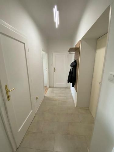 un couloir vide avec une porte blanche et du carrelage dans l'établissement City Apartment Tulln, à Tulln