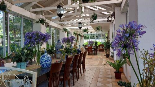 a room filled with tables and chairs with purple flowers at Pheasant Hill Bed and Breakfast in Rietvalleirand